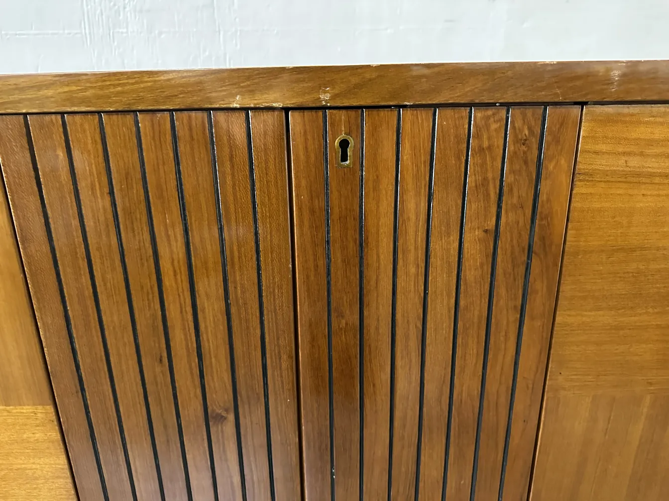 Antique bar cabinet featuring vertical lines and a keyhole