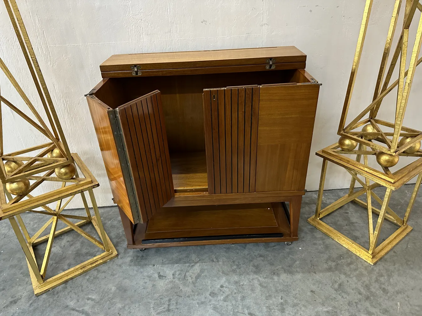 Meuble à cocktail antique avec des portes en bois et des éléments décoratifs autour