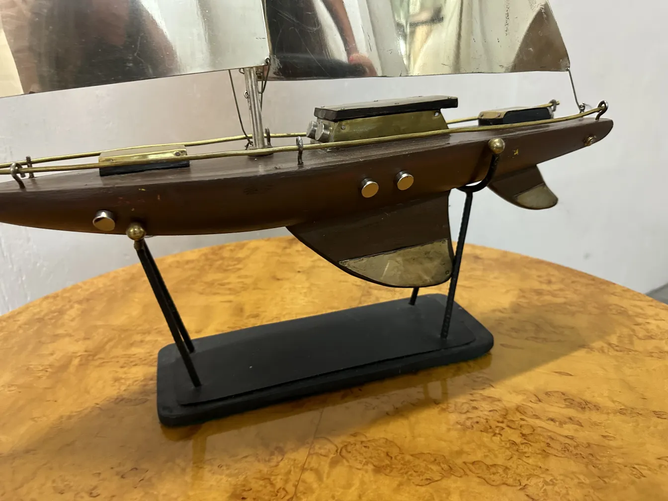 古いデザイナーの船のスケールモデル。滑らかな船体と帆を特徴としています。