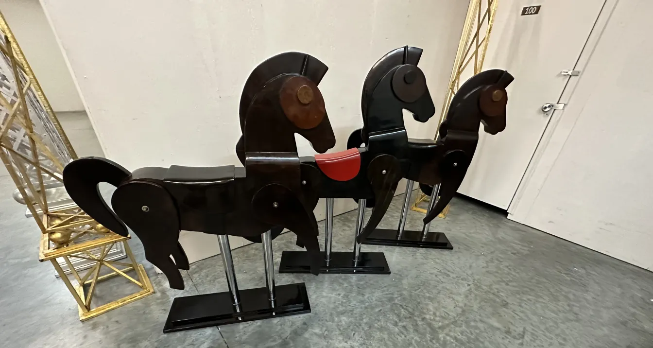 Tres caballos antiguos de madera decorativa, en un ambiente tranquilo.