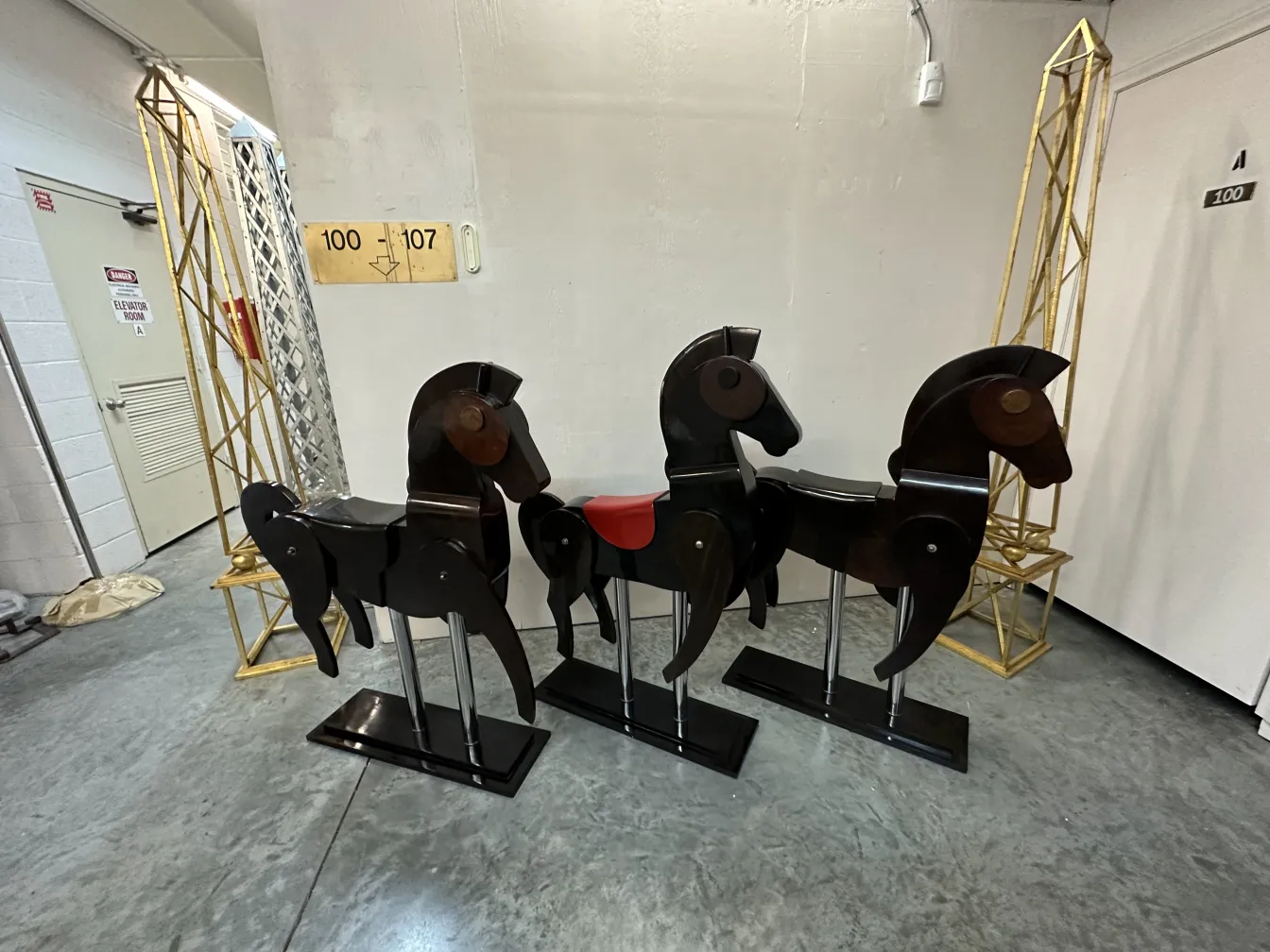 Tres caballos antiguos de madera en un ambiente moderno