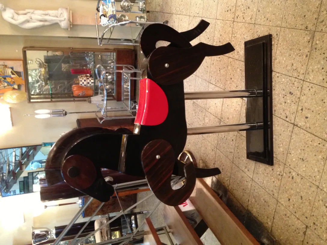 antique horse with red saddle and metal base