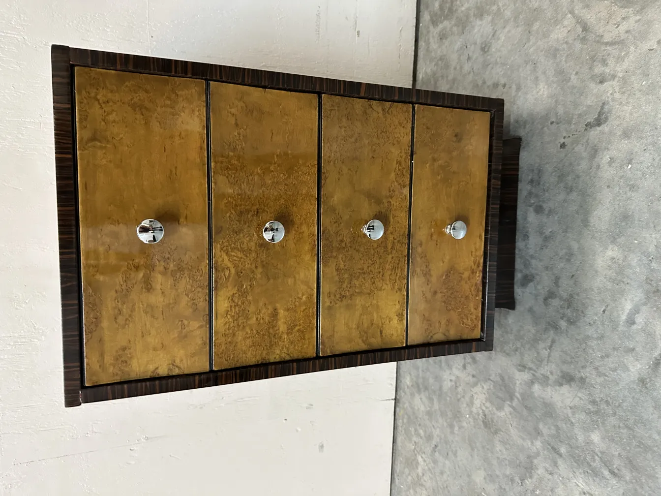 Comoda antigua de madera con cuatro divisiones, detalles dorados.