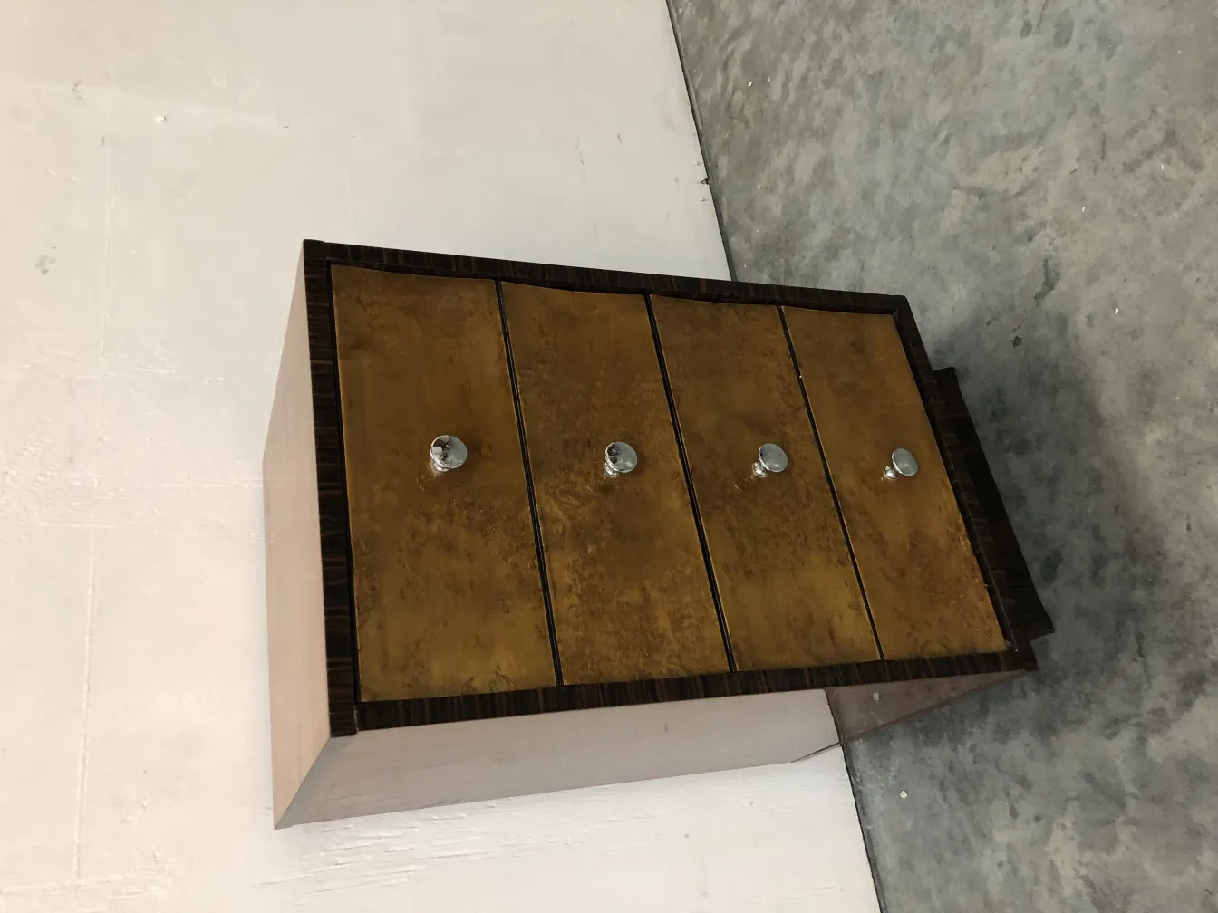 commode ancienne avec un design unique et quatre tiroirs dorés dans un cadre classique