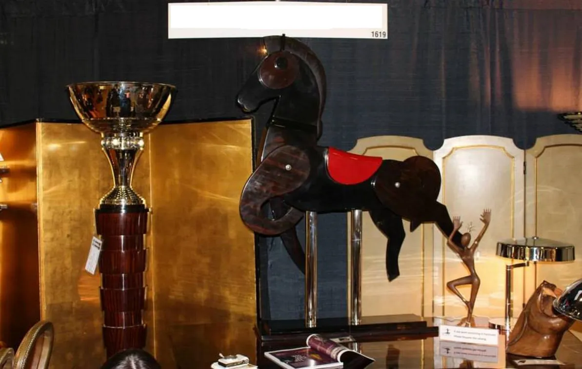 antique horse with red saddle and metal base