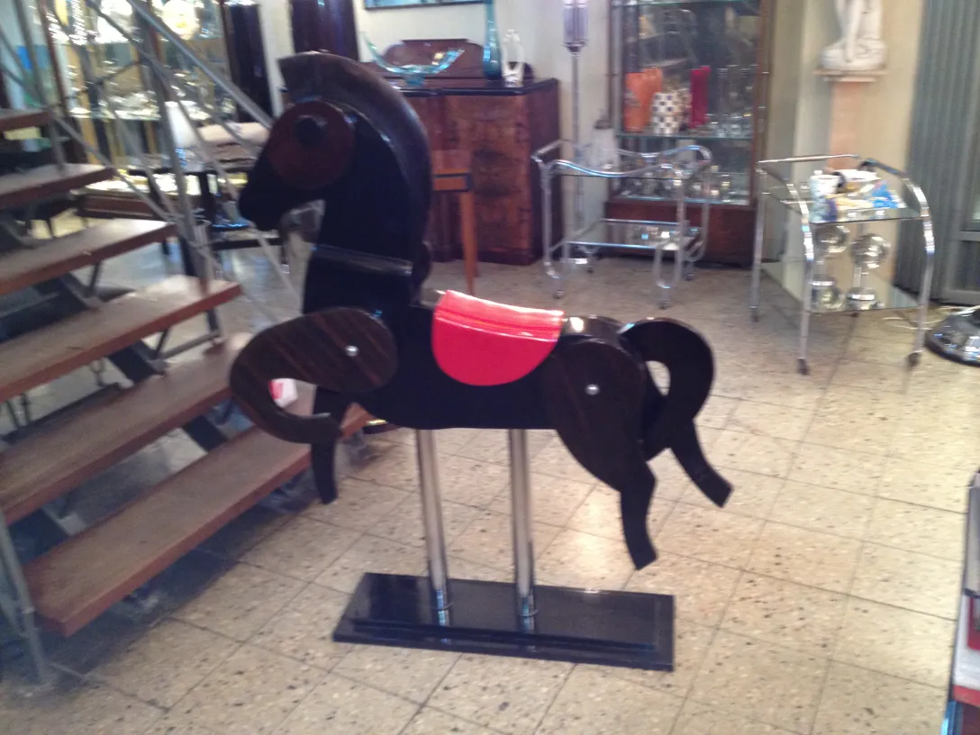 Cavallo antico con dettagli artistici in nero e rosso.
