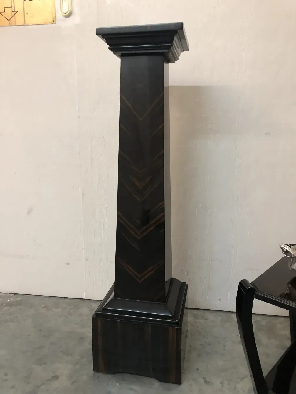 Columna antigua decorativa con diseño elegante en un fondo claro.