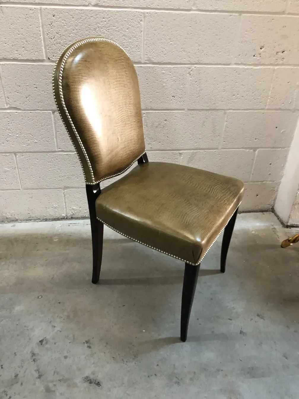 Vue de côté de 12 chaises anciennes dans un cadre simple.