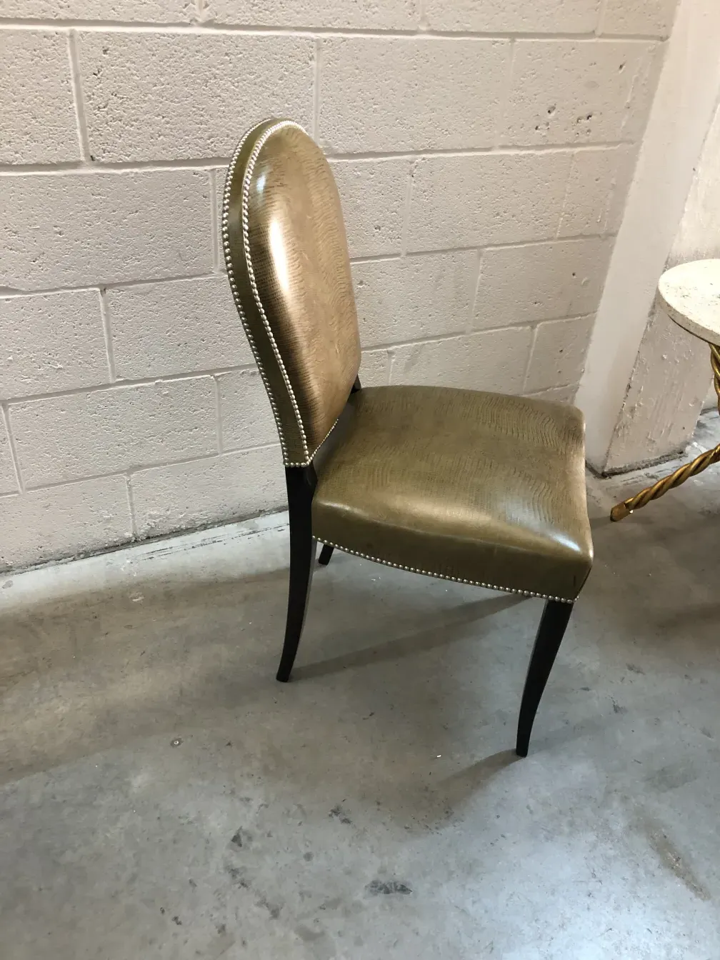 View of an elegant golden antique chair with classic design and neutral background.