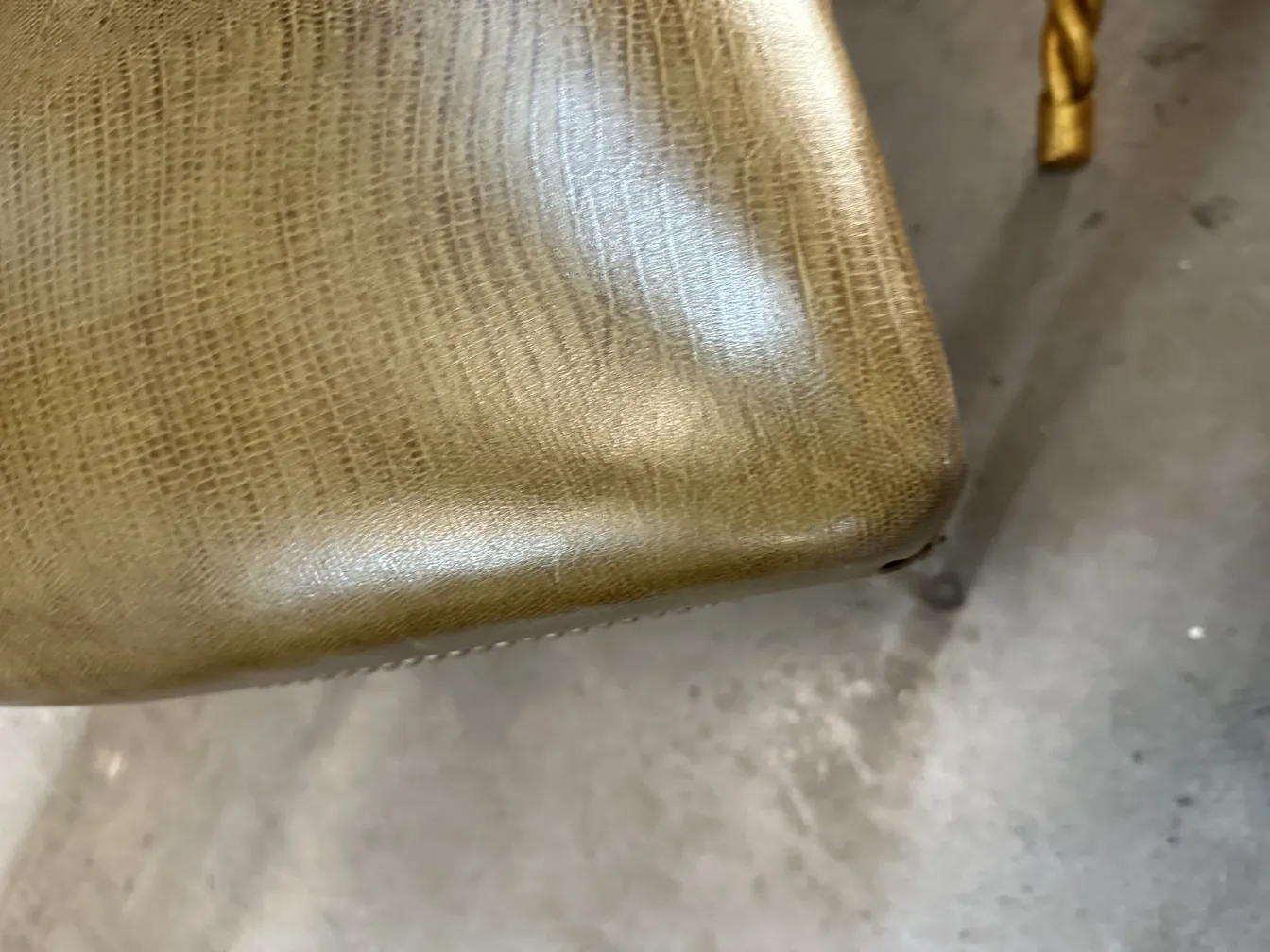 Nahaufnahme der Ecke eines antiken Stuhls mit elegantem Design. Heller Hintergrund.