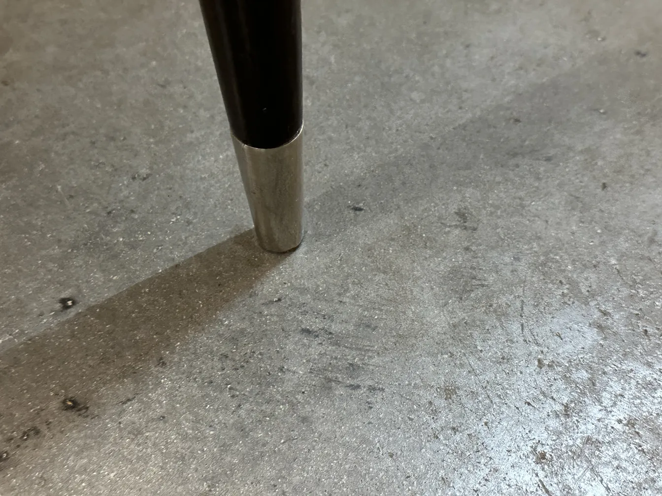 View of an antique chair base showing detailed metal foot.