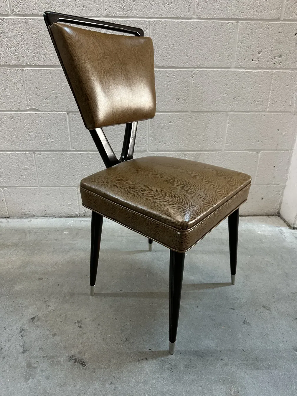 Antique chairs with unique design, triangular backrest and stylish legs in a modern setting.