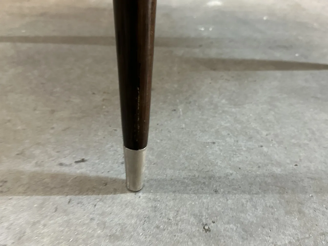 Detalle de pata de 12 sillas antiguas carlo mollino, ambiente neutral.