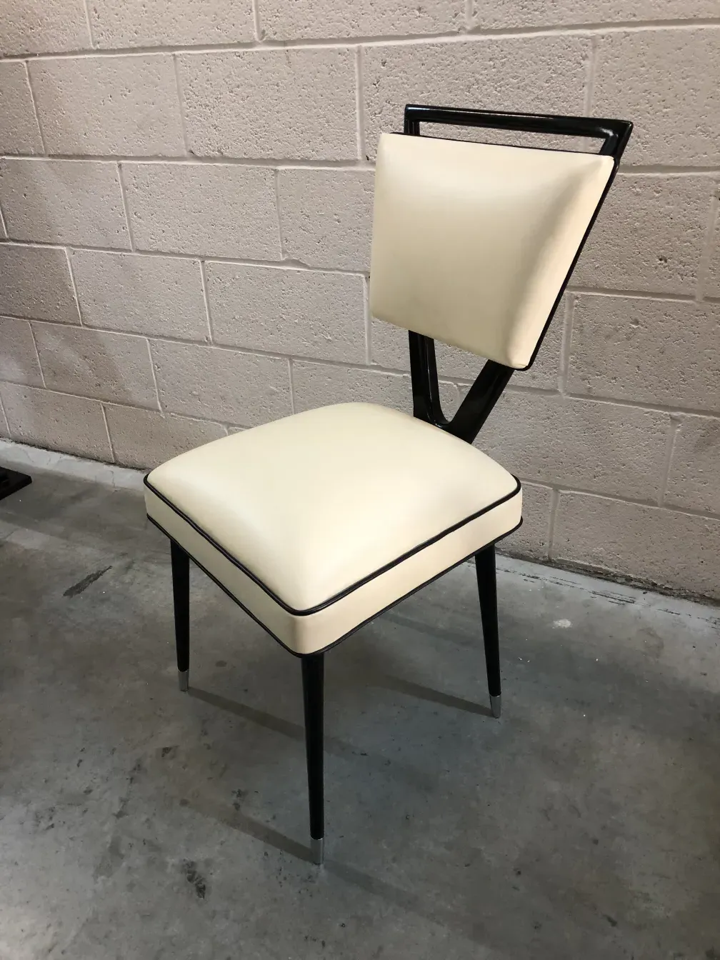 Deux chaises anciennes avec un design minimaliste dans un cadre neutre.
