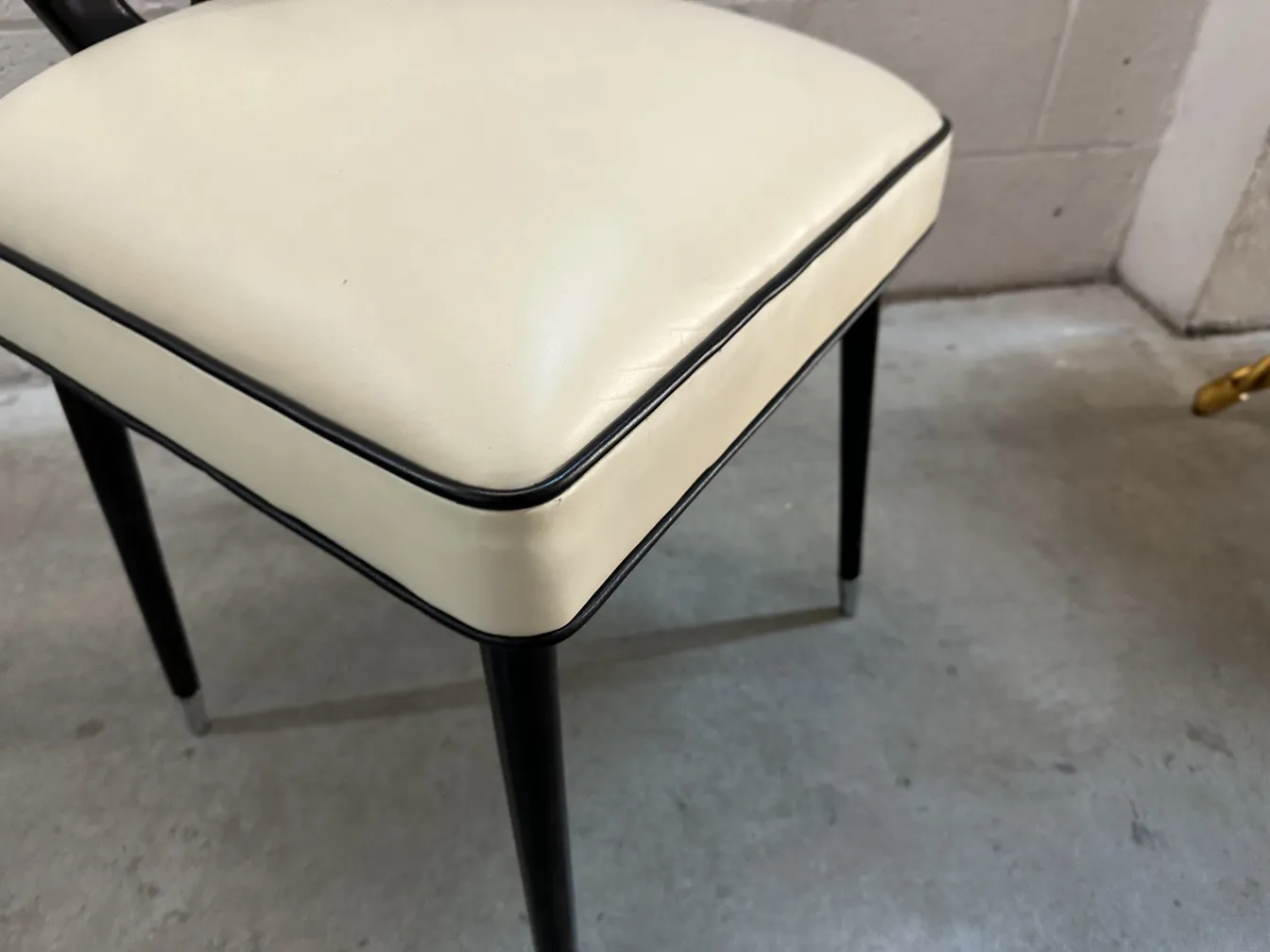 detalhe de uma cadeira antiga com design elegante e pernas pretas