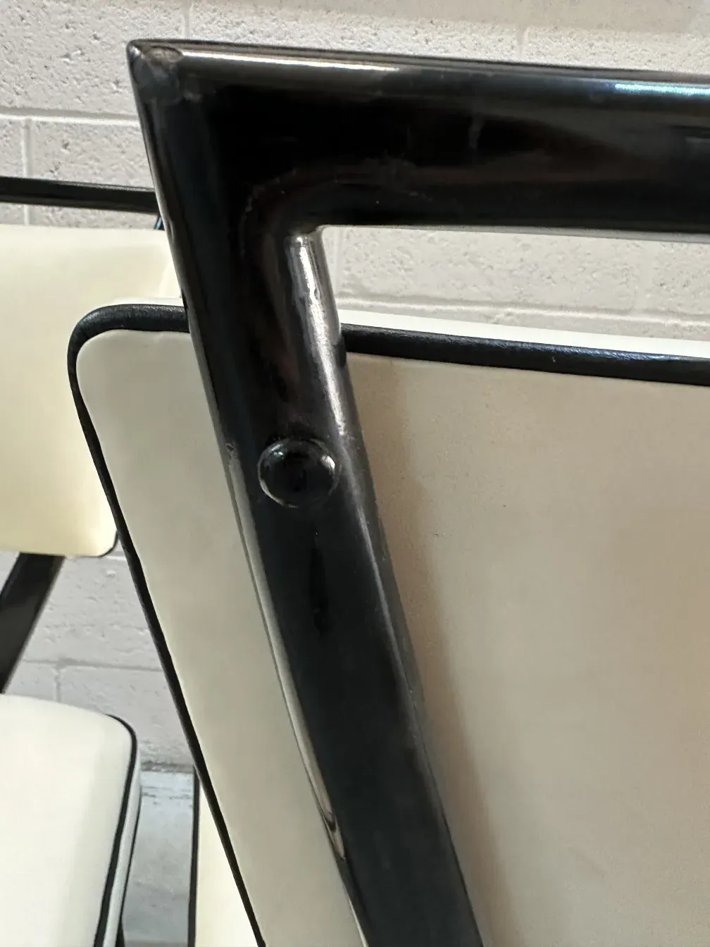 दो पुरानी कुर्सियाँ जिनका काला ढांचा और हल्का अस्तर है