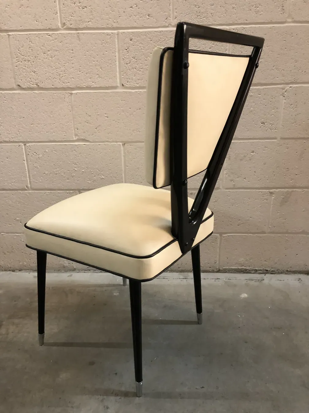 Two antique chairs with a simple and minimalist design, resting on a smooth floor.