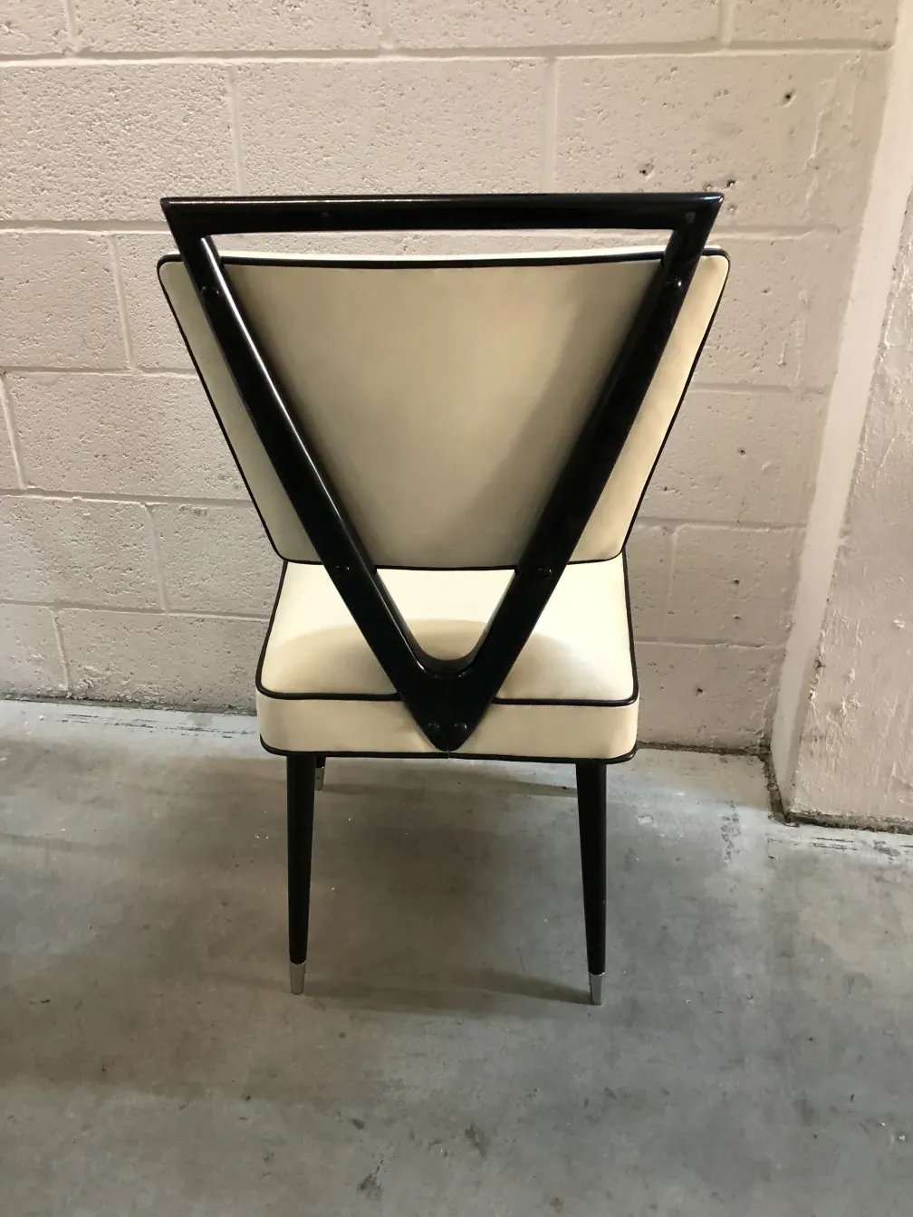 Rückansicht von zwei antiken Stühlen mit einzigartigem Design, Teil eines eleganten Ambientes.