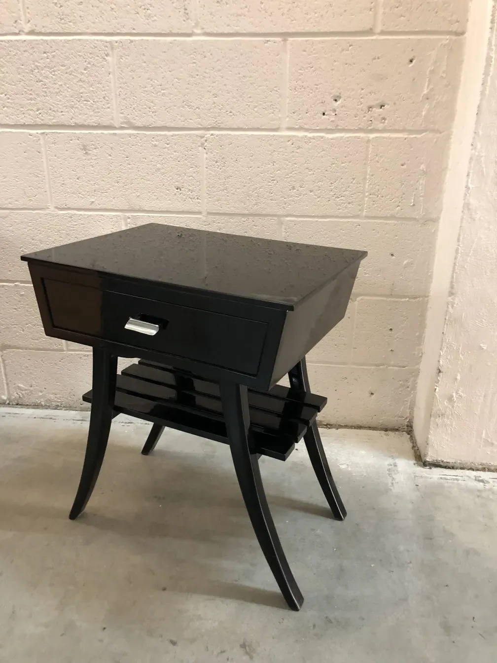 Mesa de luz antigua con un cajón y diseño elegante, ubicada en un ambiente minimalista