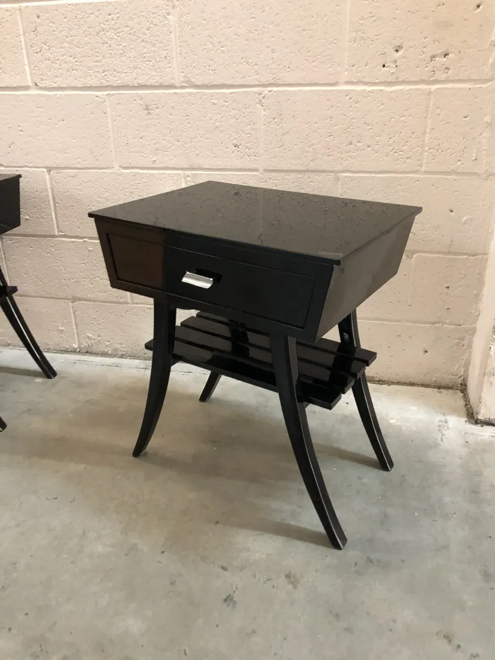 Table de chevet antique de couleur noire avec un design élégant et un tiroir. Parfaite pour la chambre.