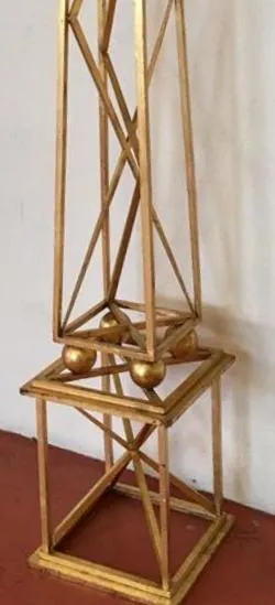 दो सुनहरे ओबिलिस्क सजावटी विवरणों के साथ एक सुरुचिपूर्ण सेटिंग में