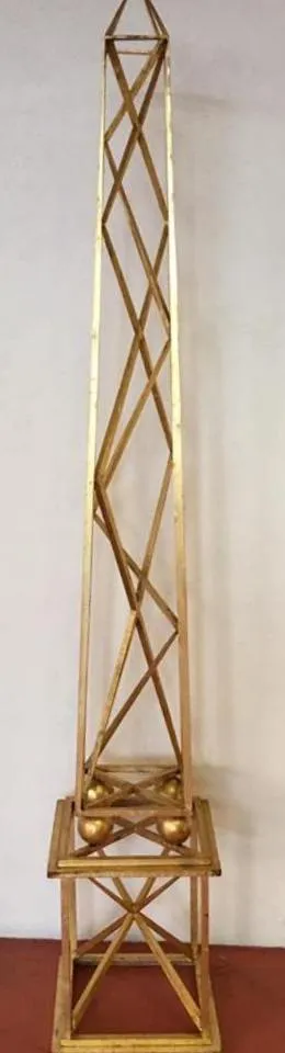 Due obelischi antichi dorati con un design decorativo alla base.