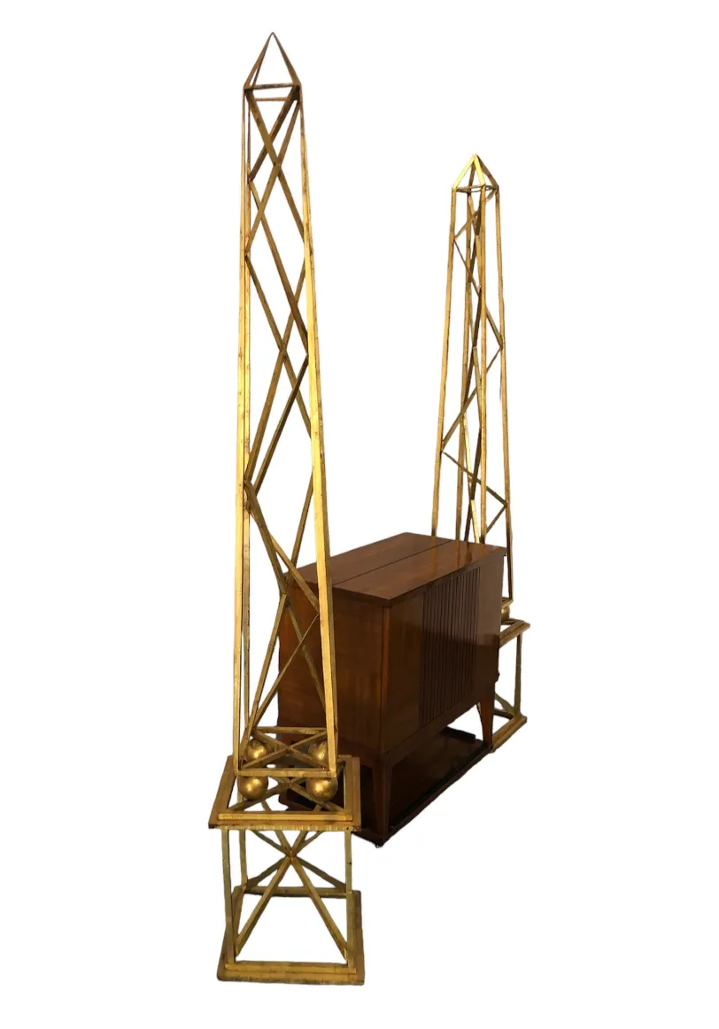 two decorative golden obelisks in an elegant setting
