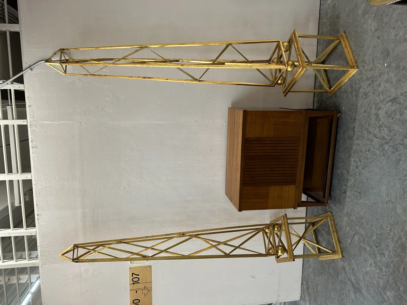 two antique obelisks with decorative details in a neutral setting