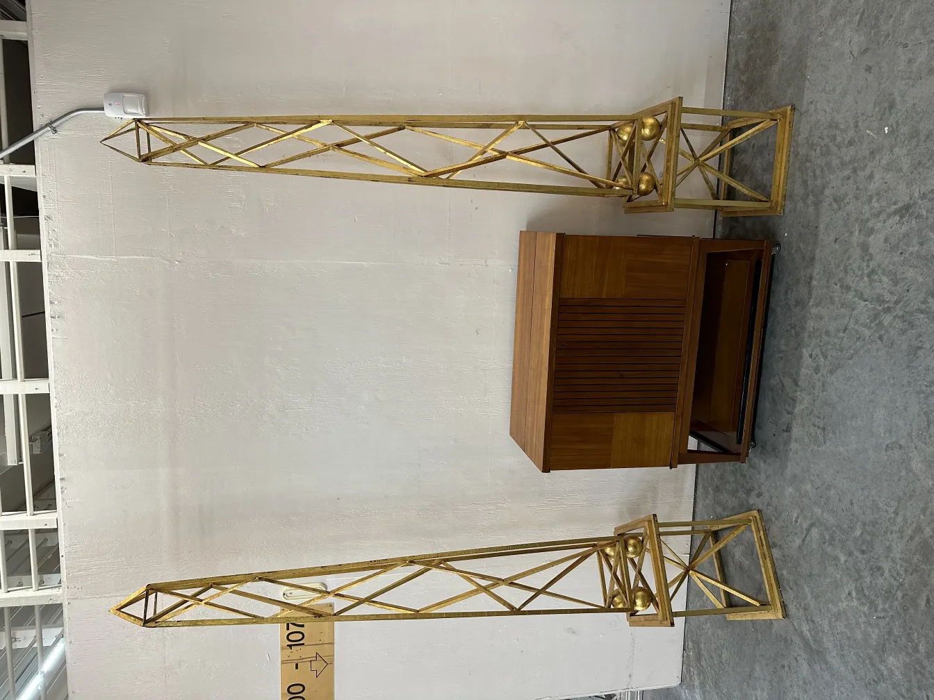 two antique gold obelisks in a decorative setting