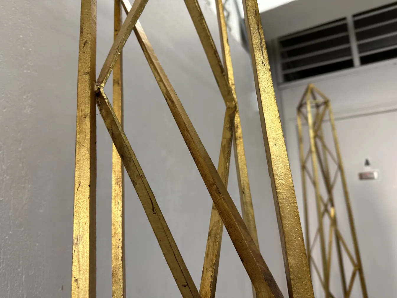 Two antique decorative obelisks in a neutral setting.