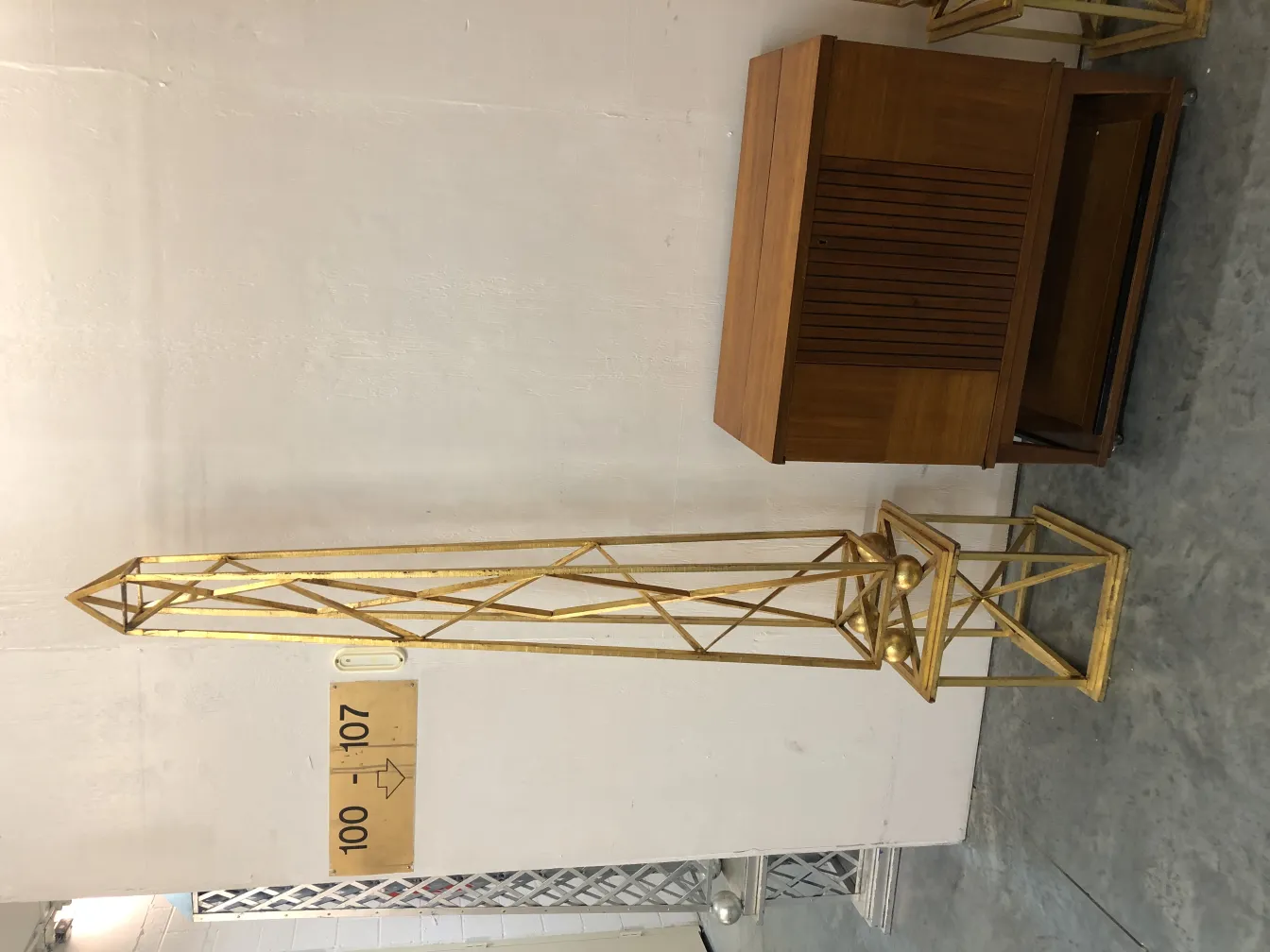 Conjunto de 2 obeliscos antiguos decorativos en un entorno sobrio.