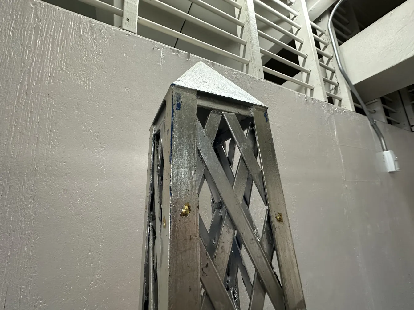 Antique obelisk with decorative details in a modern setting.