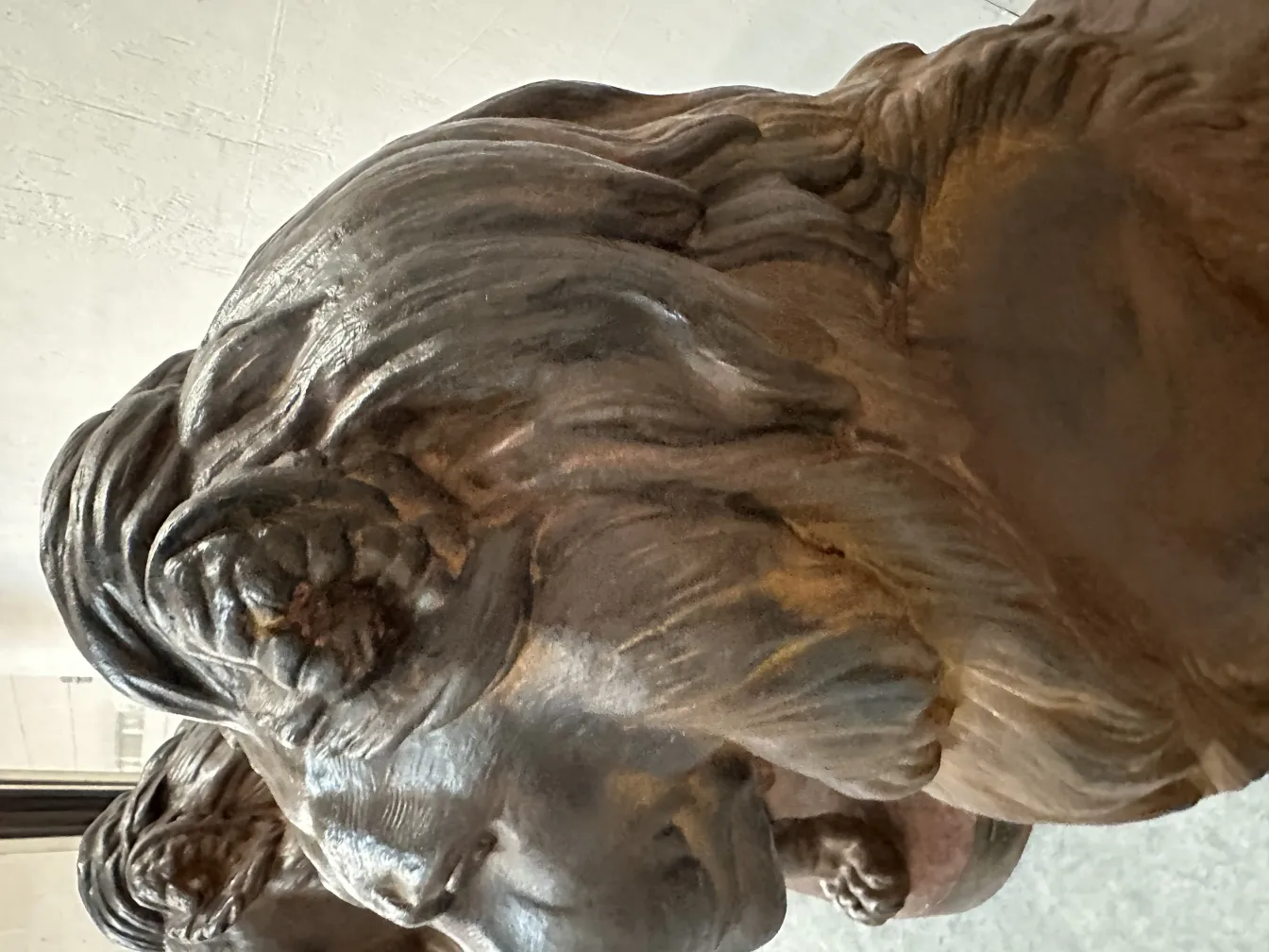 Escultura antigua de 2 leones, con detalles acentuados y un fondo neutro.