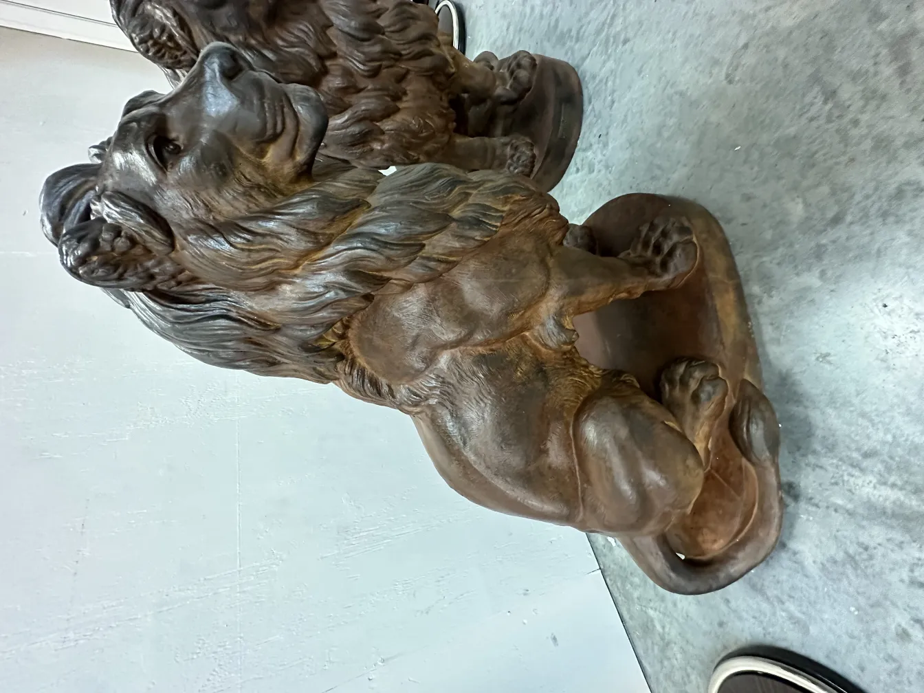 dos leones antiguos en posición sentada con detalle en el pelaje