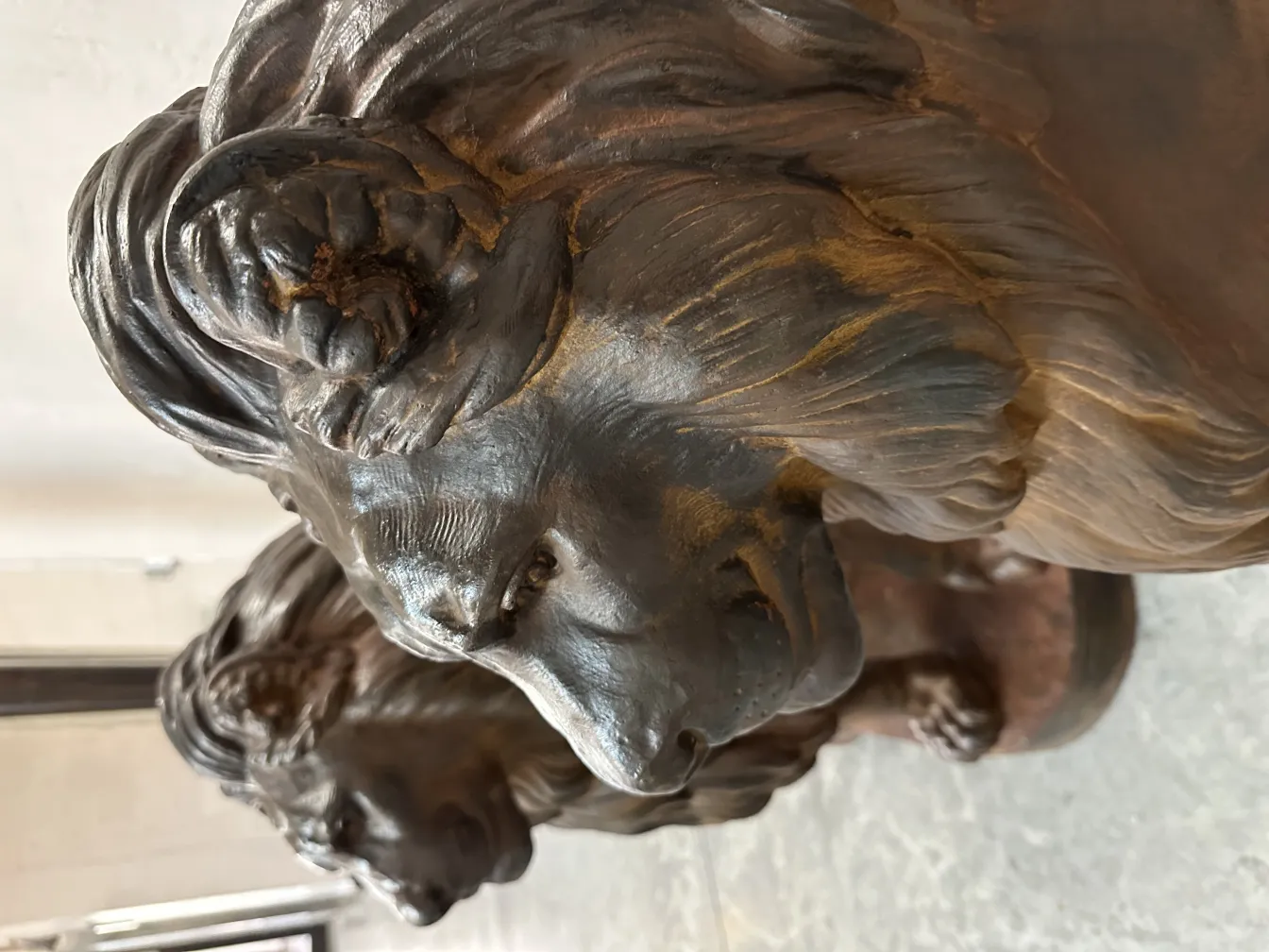 Escultura de 2 leones en antigüedad, detalle de los rostros.