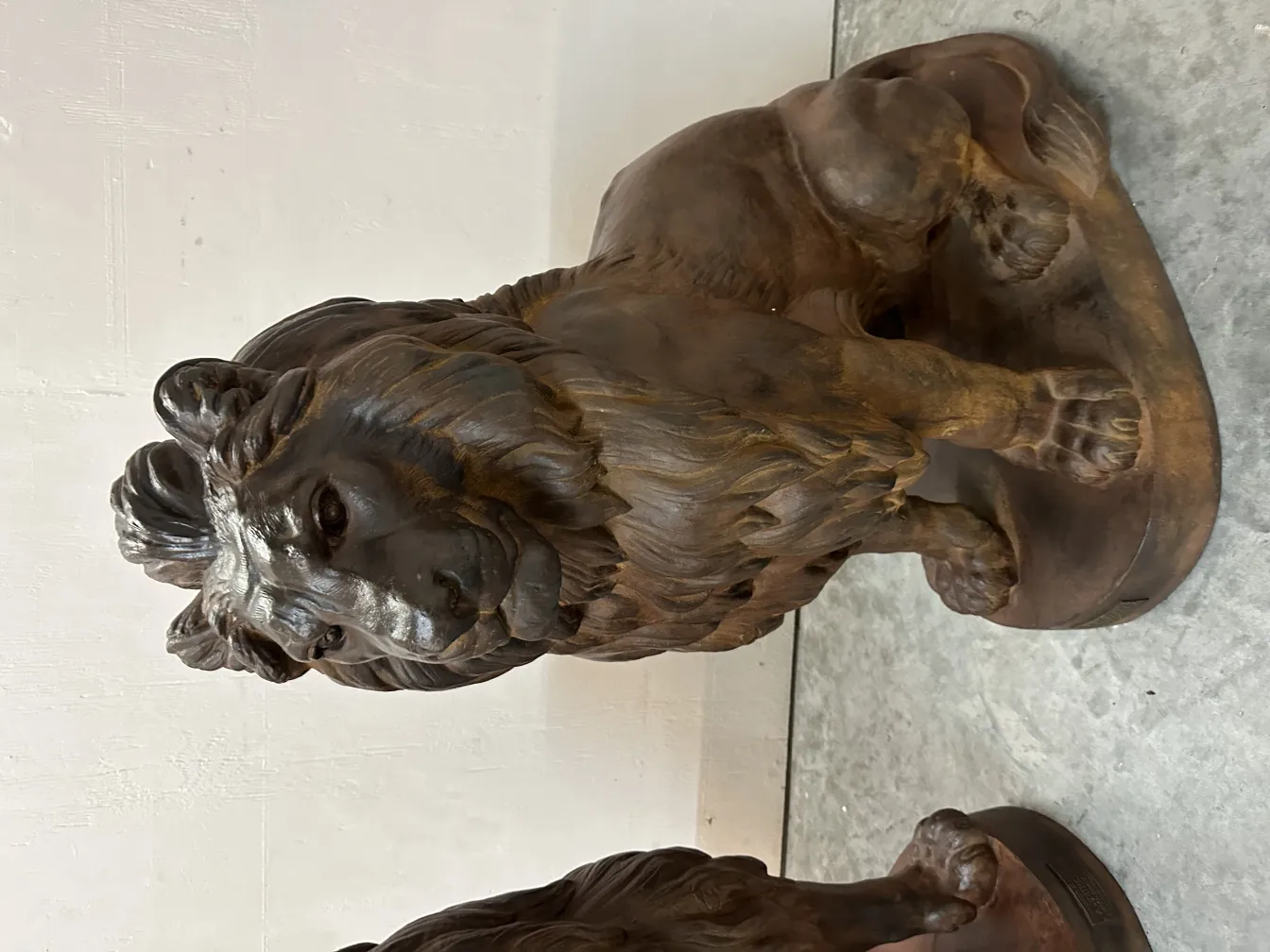 escultura de 2 leões antigos, com detalhes realistas e majestosos, em um ambiente minimalista.