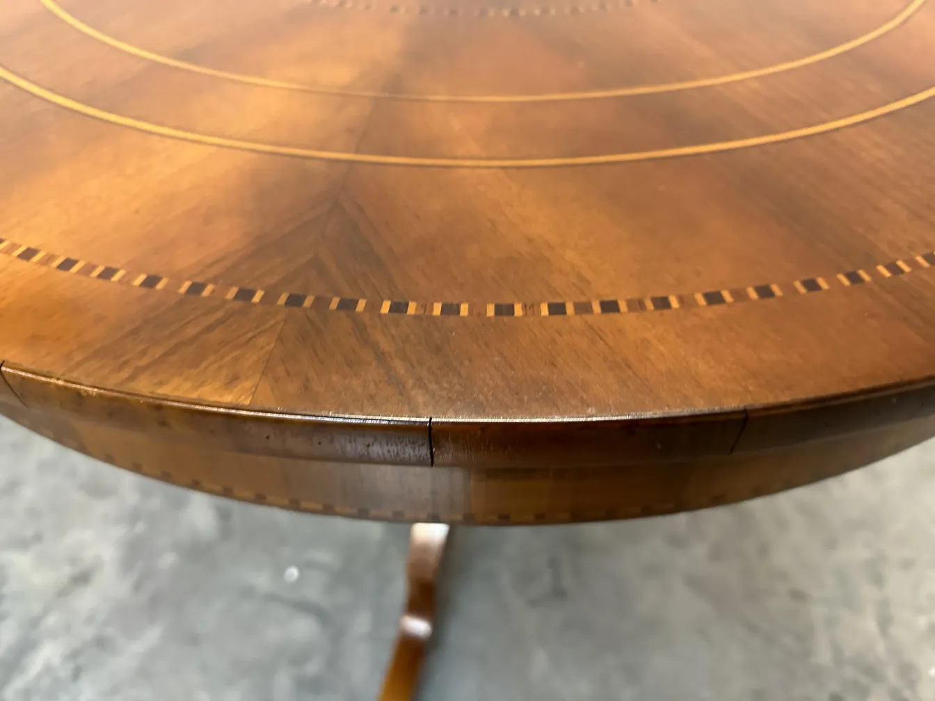 Runder antiker Tisch mit dezenten Verzierungen, eleganter Rahmen.