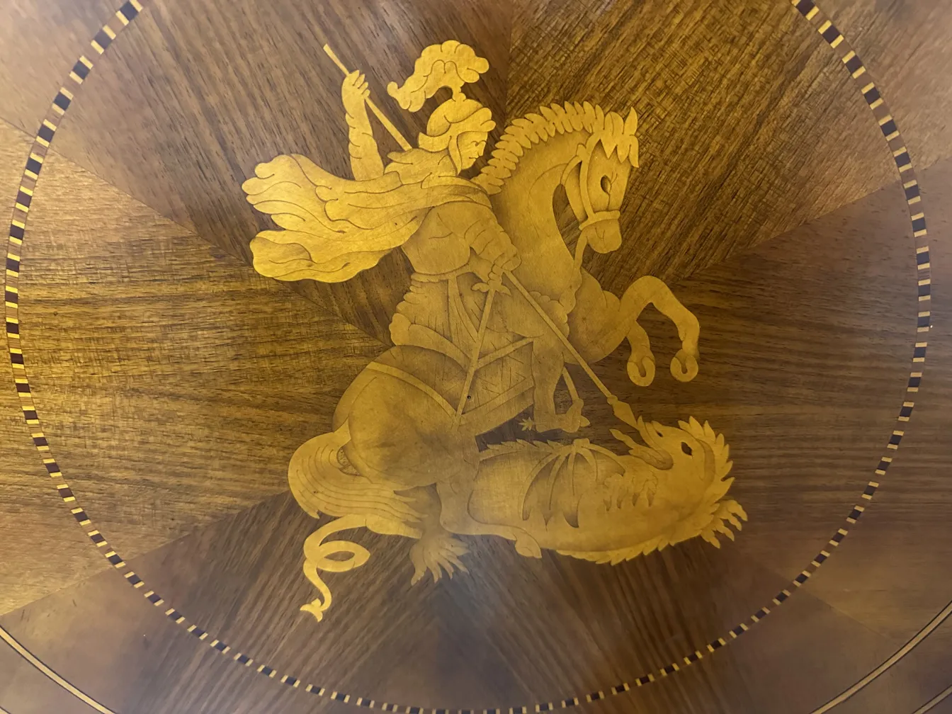 table ancienne présentant un design complexe de guerre et de dragon.