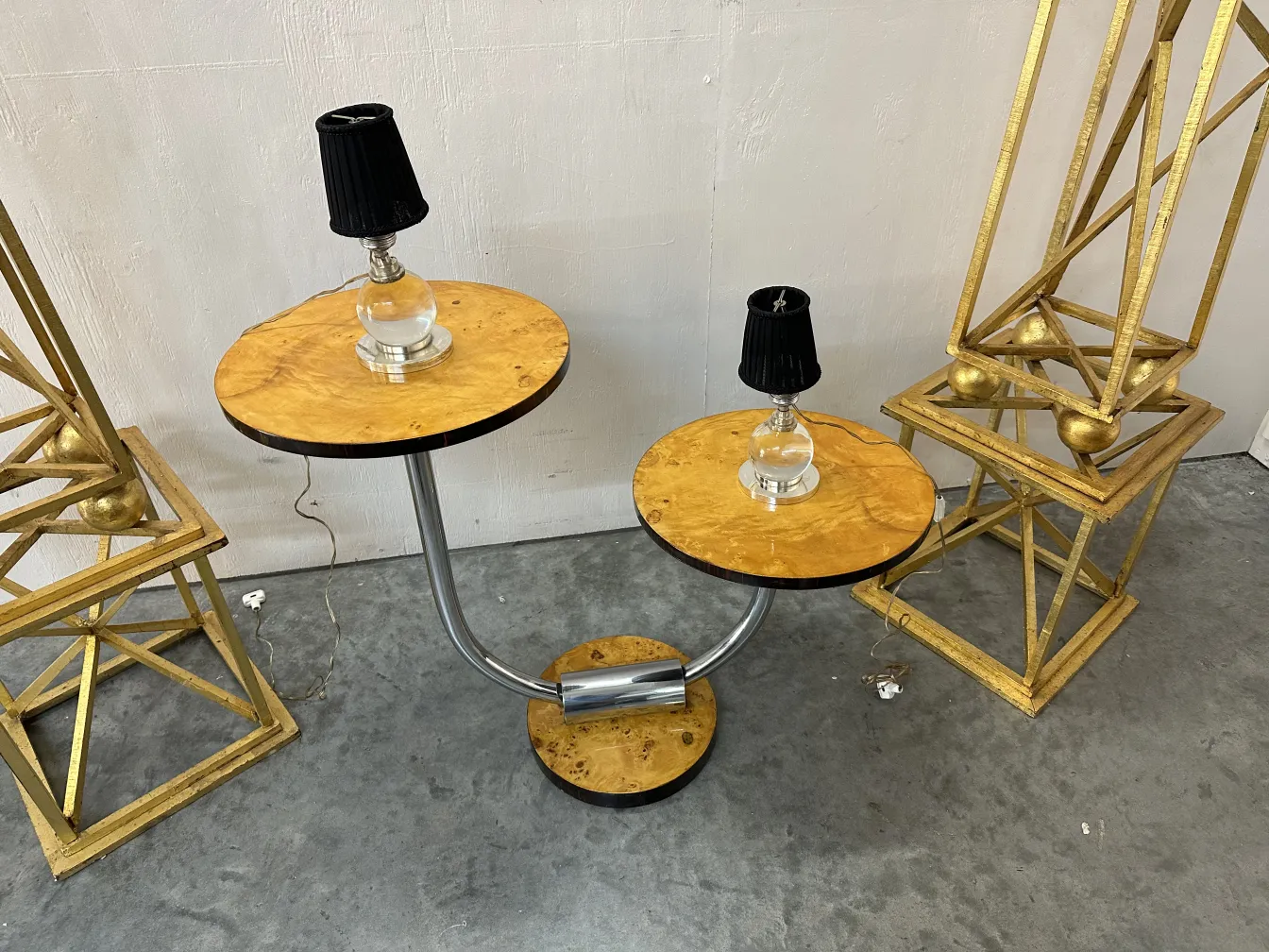 Due lampade da tavolo antiche di Jacques Adnet con basi rotonde e paralumi neri. Ambiente con decorazioni dorate.