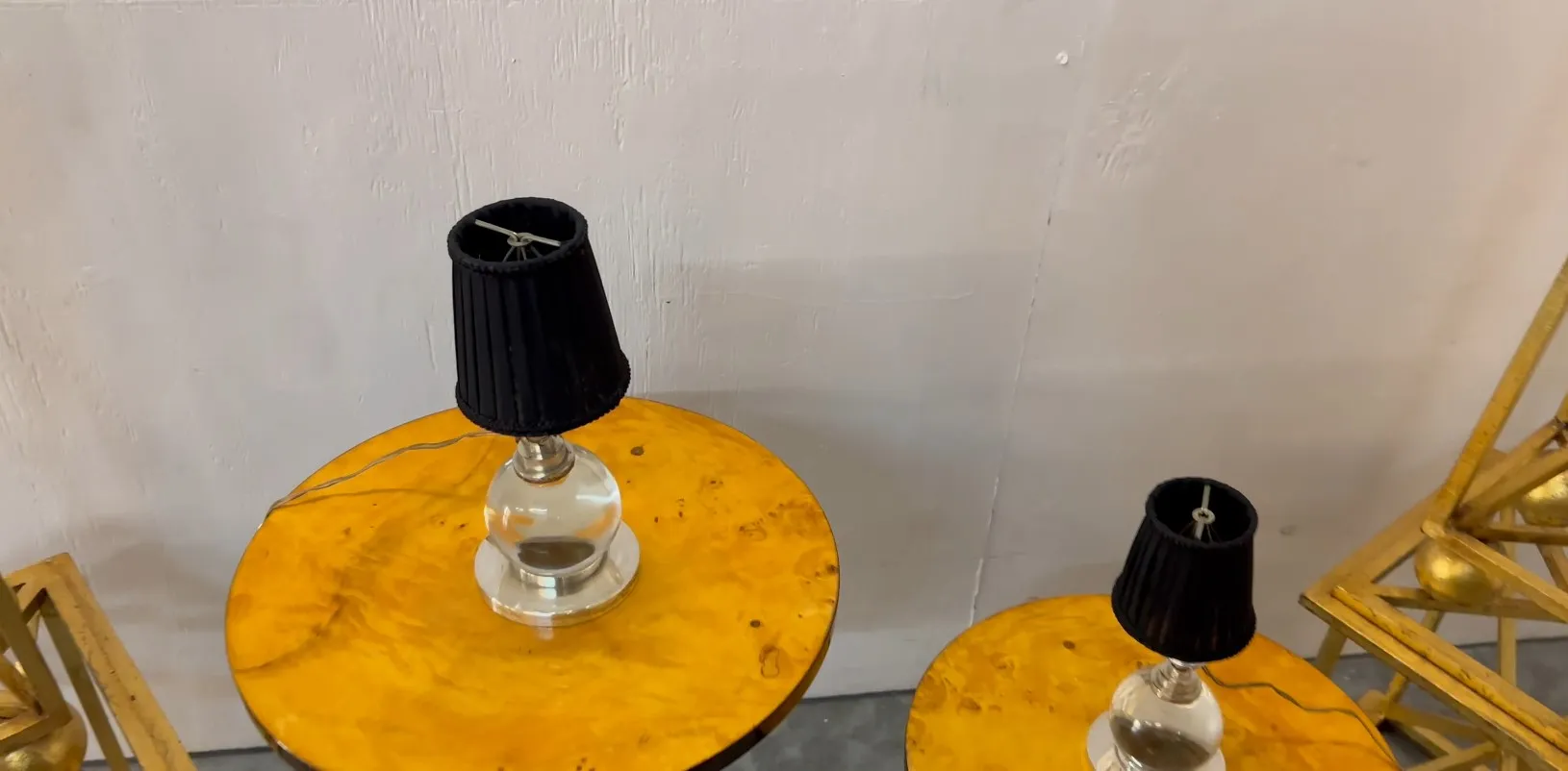 two antique table lamps with black shades on yellow tables