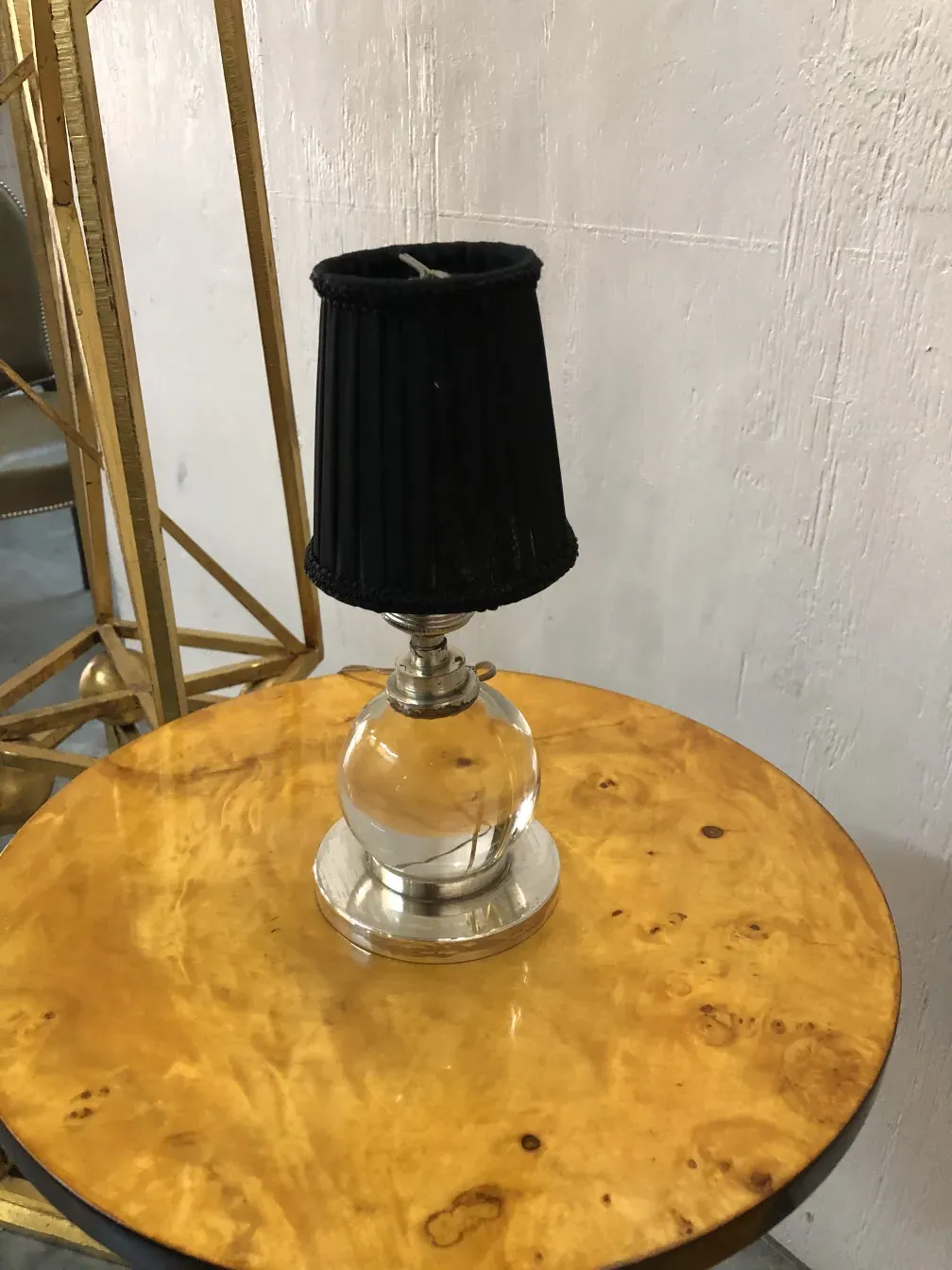 Two antique table lamps with decorative bases and black shades in an elegant setting.