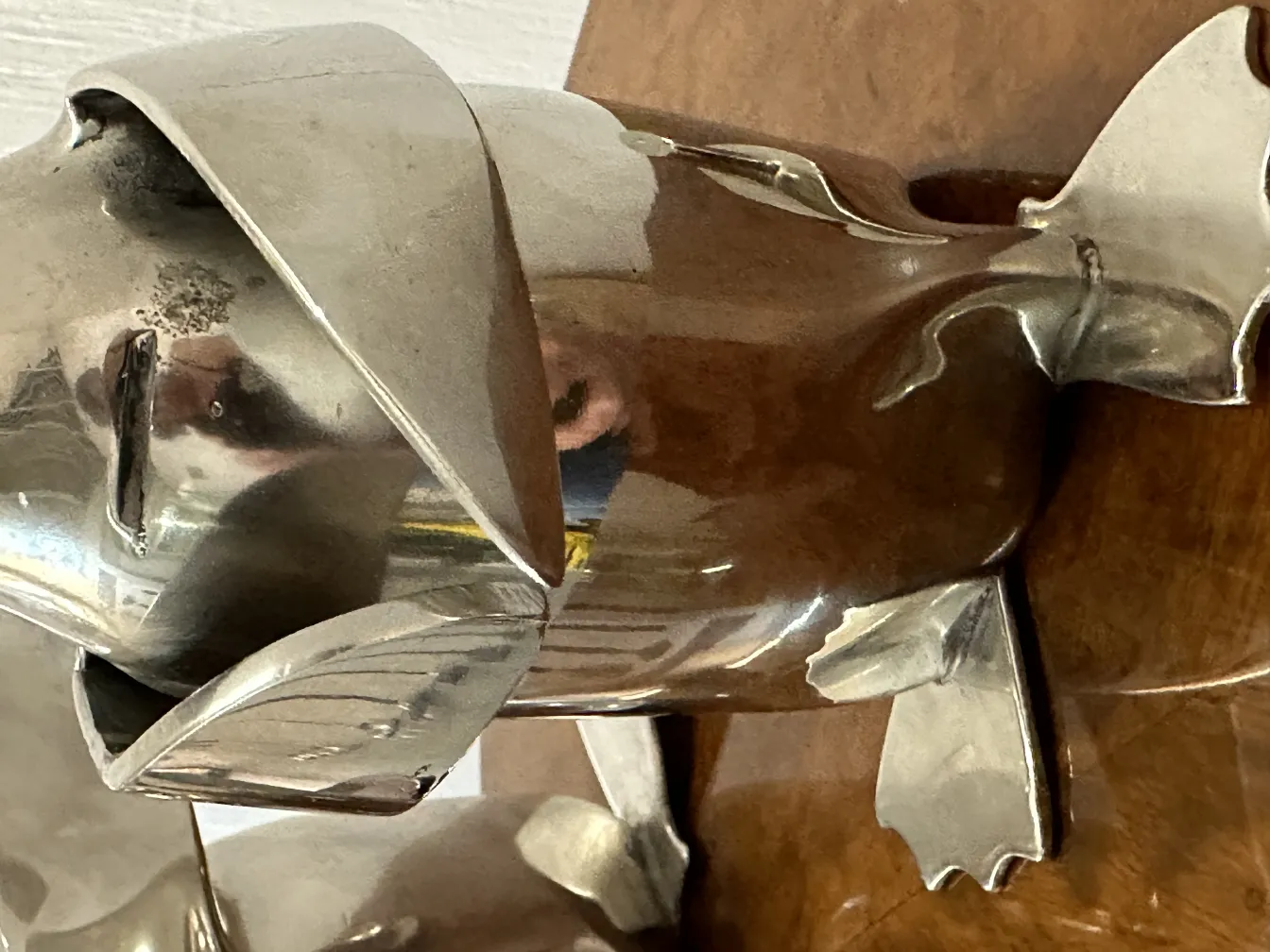 antike Pinguinskulptur vor einem Holz-Hintergrund