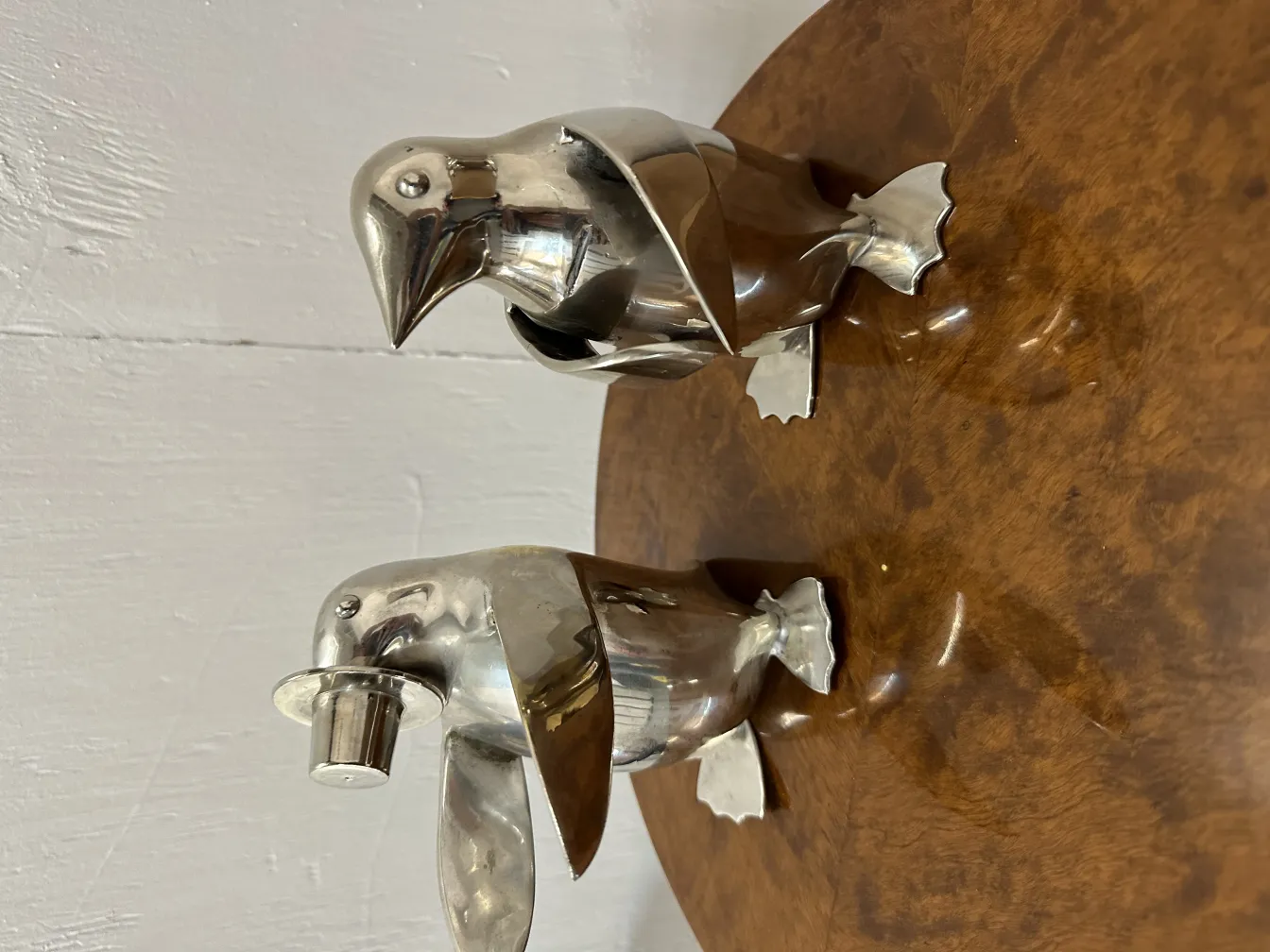 dos pingüinos antiguos decorativos en un fondo marrón