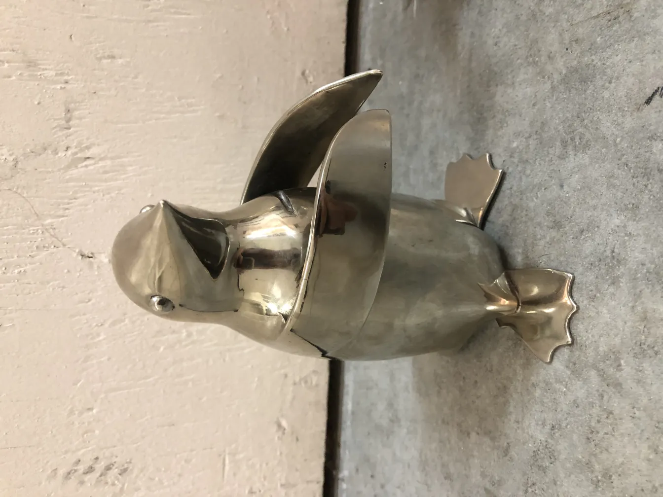 sculpture antique de 2 pingouins debout avec des détails brillants sur un fond neutre