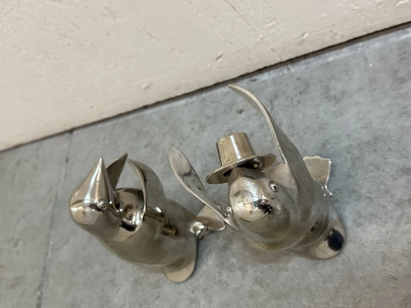 two decorative metallic penguins with a hat