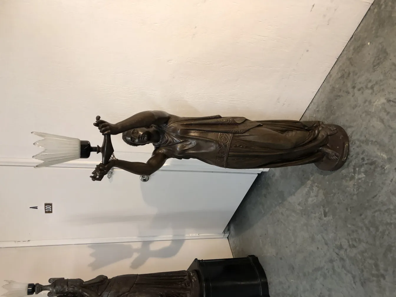 antique sculpture with figure holding light