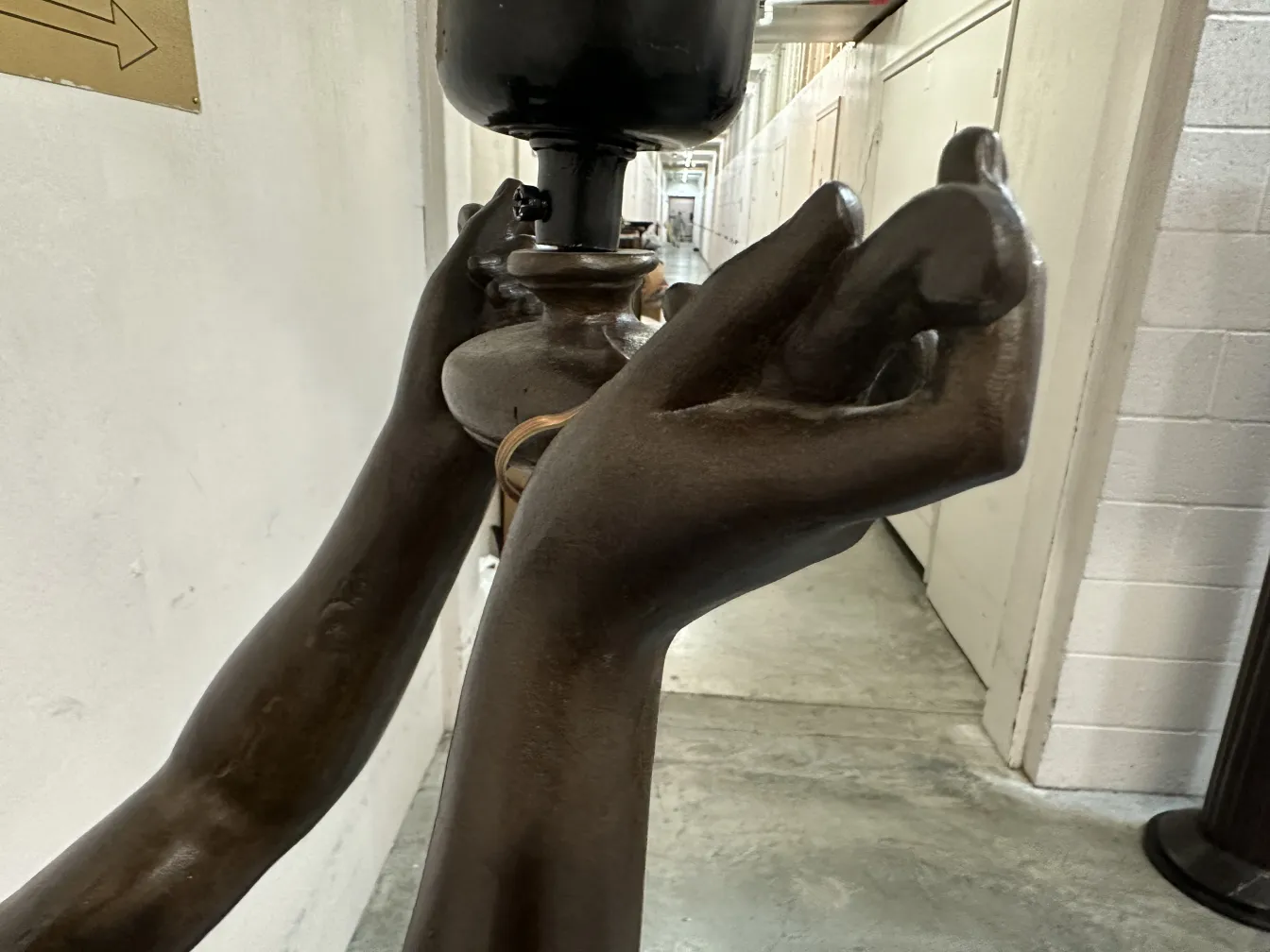 escultura antiga com mãos expressivas em ambiente iluminado