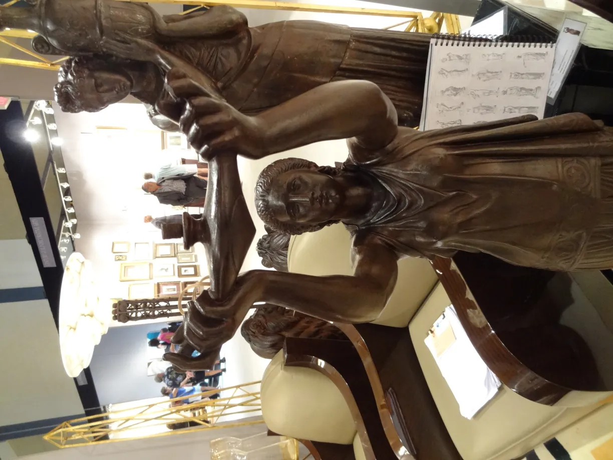 Antike Skulptur mit Figur, die einen Gegenstand hält, Ausstellungsumgebung.