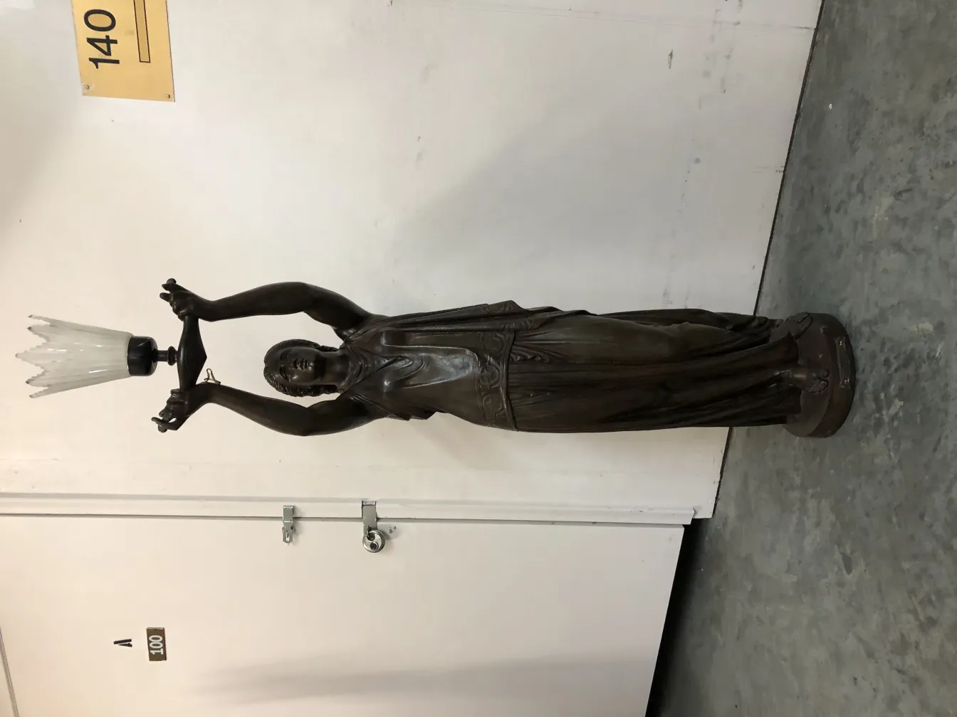 scultura antica val-dosne con figura femminile che tiene la luce