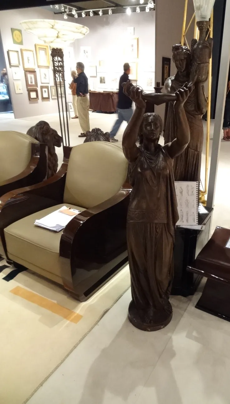 escultura antigua de mujer sosteniendo una lámpara